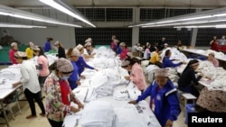 FILE - Employees work at a garment factory in Kandal province, Cambodia, Dec. 12, 2018. 