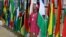 A delegate poses in front of flags during the opening of the U.S.-sub-Saharan Africa trade forum to discuss the future of the African Growth and Opportunity Act, AGOA, at the NASREC conference center in Johannesburg, South Africa, November 3, 2023. 