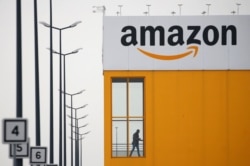 FILE - The logo of Amazon is seen at the company logistics center in Lauwin-Planque, northern France, March 19, 2020.