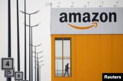 FILE - The logo of Amazon is seen at the company logistics center in Lauwin-Planque, northern France, March 19, 2020.