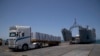 ARCHIVO: Soldados estadounidenses junto a camiones cargados con ayuda humanitaria en el muelle flotante construido por EEUU frente a la costa de la Franja de Gaza, el 25 de junio de 2024.