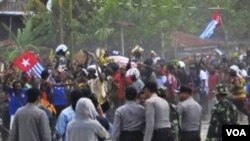 Para anggota Polri melepaskan tembakan peringatan saat beberapa warga Papua melakukan unjuk rasa dengan mengibarkan bendera Bintang Kejora di kabupaten Timika (1/12).