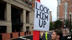 Protesters Gayelynn Taxey, left, and Danny Hastings, stand in front of the Alexandria Federal Court in Alexandria, Virginia, July 31, 2018, on day one of Paul Manafort's trial. 