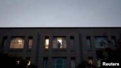 FILE - An employee inside Pakistan's embassy in Washington looks out a window, Nov. 5, 2007.