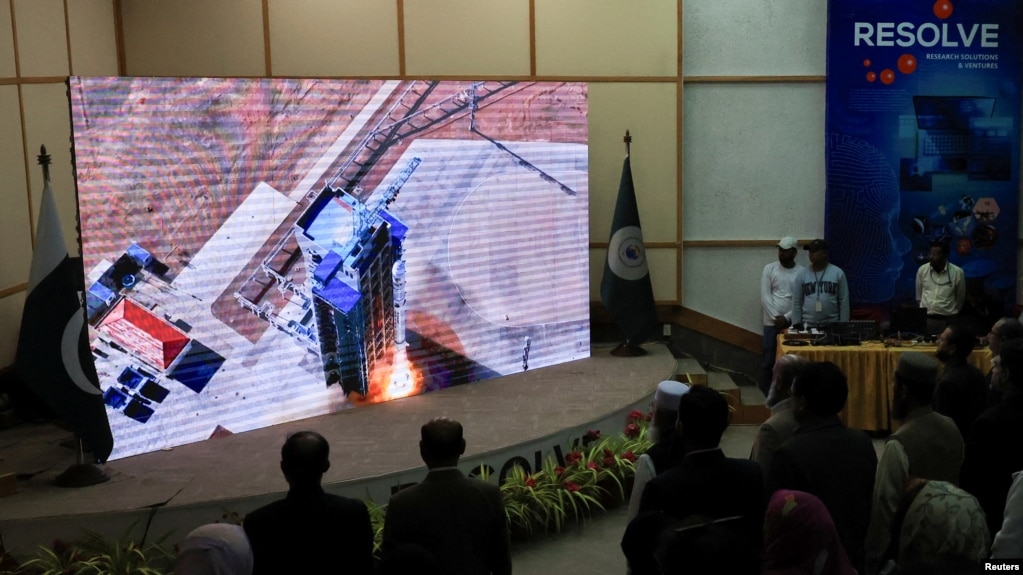 FILE - People watch a screen displaying the launch of Pakistan's indigenous Electro-Optical (EO-1) satellite from the Jiuquan Satellite Launch Centre in northern China, at the Pakistan Space and Upper Atmosphere Research Commission Complex in Karachi, Jan. 17, 2025.