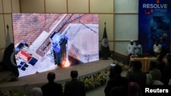 FILE - People watch a screen displaying the launch of Pakistan's indigenous Electro-Optical (EO-1) satellite from the Jiuquan Satellite Launch Centre in northern China, at the Pakistan Space and Upper Atmosphere Research Commission Complex in Karachi, Jan. 17, 2025.