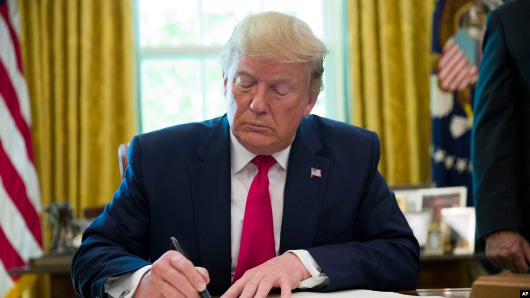President Donald Trump listens to a reporter's question after signing an executive order to increase sanctions on Iran.