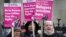 Stand Up To Racism campaigners hold banners outside the High Court in London, Dec. 19, 2022. 