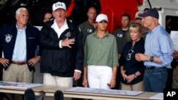 Wapres AS Mike Pence (kiri), Presiden AS Donald Trump, ibu negara Melania Trump mendengarkan penjelasan mengenai upaya pemulihan pasca badai Irma di Ft. Myers, Florida, Kamis (14/9).