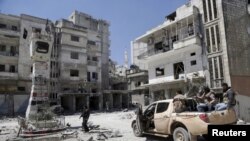 Rebel fighters inspect a site damaged by what activists said was shelling by warplanes loyal to Syria's President Bashar al-Assad in Jisr al-Shughour town, after the rebels took control of the area, April 26, 2015.