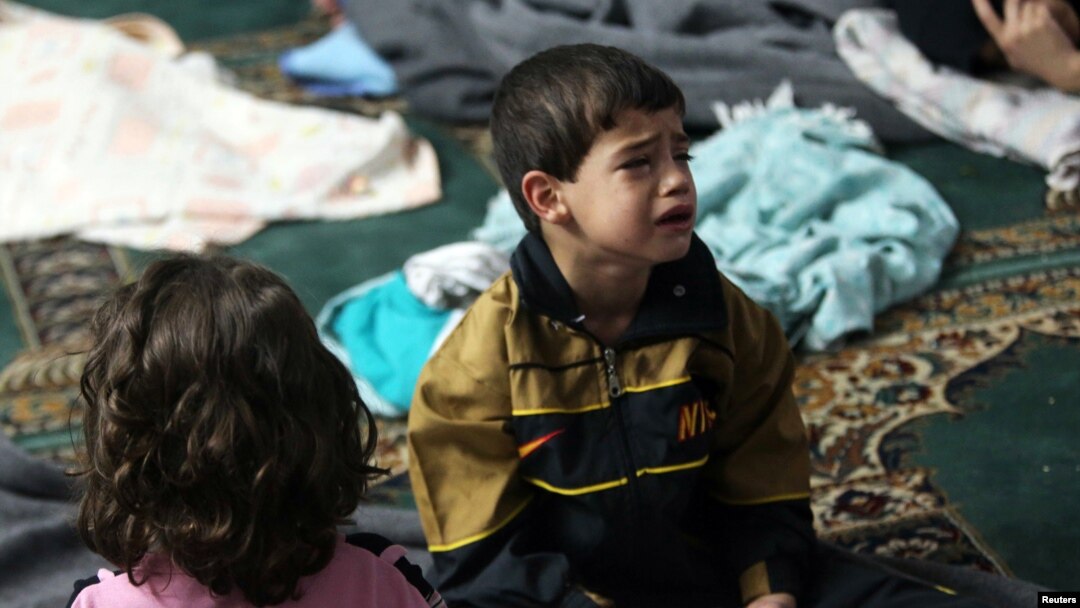 Seorang anak laki-laki yang bertahan dari apa yang para aktivis sebut serangan gas menangis di tempat penampungan di dalam masjid di Durma, Damaskus (21/8). (Reuters/Mohamed Abdullah)