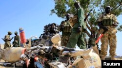 Binh lính quân đội Nam Sudan bên cạnh một chiếc xe gắn máy bị phá hủy gần sân bay Bor, tây bắc thủ đô Juba, ngày 25 tháng 12, 2013. 