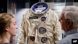 Visitors stand before the spacesuit worm by astronaut Neil Armstrong that was used on his Gemini VIII mission at the Armstrong Air & Space Museum, Wednesday, June 26, 2019, in Wapakoneta, Ohio. 