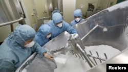 Employees work on the production line of an anti-malarial drug that Chinese officials said has curative effect on the novel coronavirus disease, at a pharmaceutical company in Nantong, Jiangsu province, China Feb. 27, 2020. 