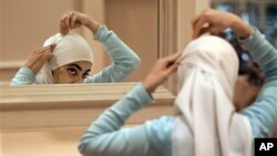 Sadaf Butt, de l'Alabama, ajuste son hijab dans un miroir à la 43e conférence annuelle de la Société islamique d'Amérique du Nord, le 1er septembre 2006, à Rosemont, en Illinois.