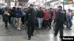 Pazar günü Münih tren istasyonuna giriş yapan mülteciler