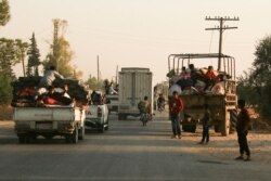 Syrians flee shelling by Turkish forces in Ras al Ain, northeast Syria, Oct. 9, 2019.