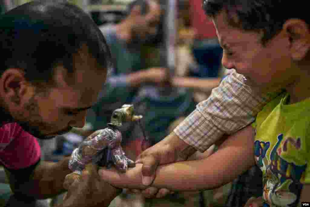 Older children get a cross tattoo on their right hand as a cultural obligation for Coptic Christians in Egypt. Sunday, August 18, 2019.