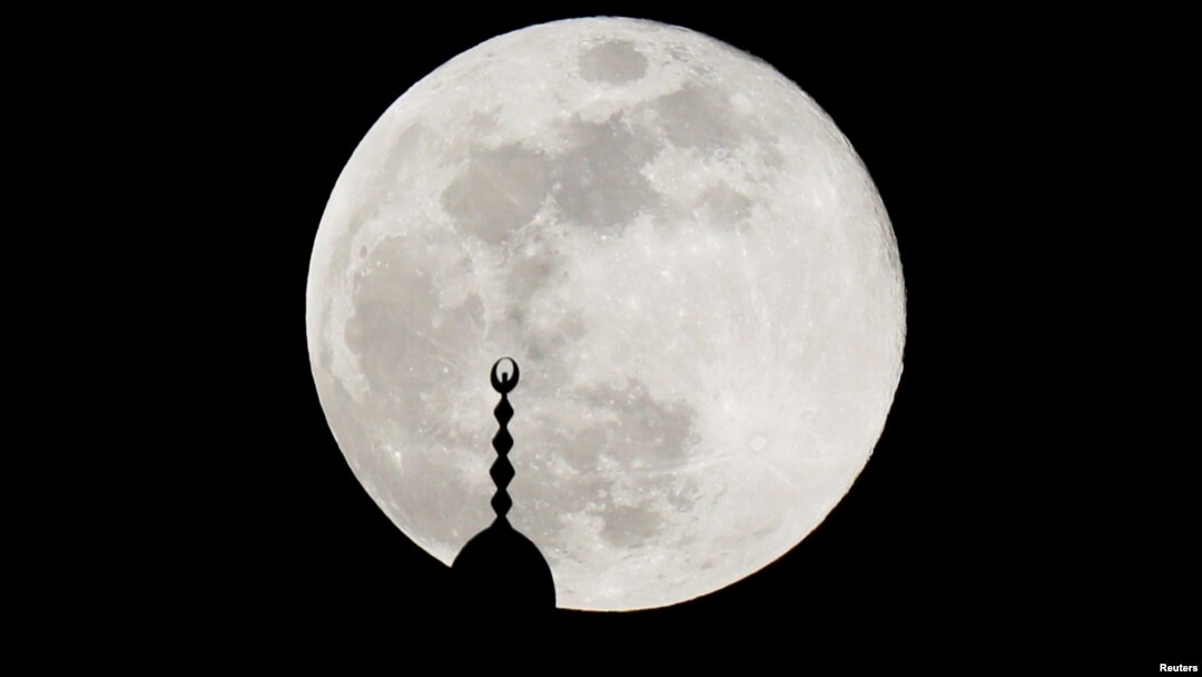 Bulan purnama menyinari menara masjid di Amman, Yordania, 7 Mei 2020. (Foto: Reuters)