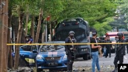 Agentes de policía inspeccionan el área exterior de una iglesia donde ocurrió una explosión en Makassar, Sulawesi del Sur, Indonesia, el domingo 28 de marzo de 2021.