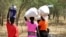 FILE - Women and girls walk back after getting food in Bentiu, a 38-kilometer journey, using a path through the bush for fear of being attacked on the main road, near Nhialdu in South Sudan. Rape has been used widely as a weapon in South Sudan.