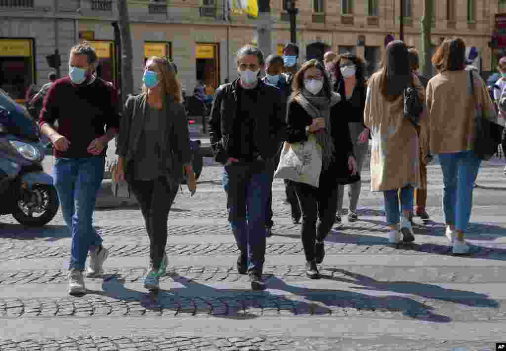 خیابان اعیان نشین و مشهور شانزه‌لیزه که از معابر اصلی شهر پاریس است، با حضور مردمی که ماسک به صورت زده اند. 