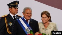 El Salvador's new president Salvador Sanchez Ceren (C) is seen with his wife Margarita Villalta after receiving the presidential sash during his swearing-in ceremony in San Salvador, June 1, 2014.