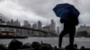 ARCHIVO - Un hombre se para cerca del East River y el puente de Brooklyn, en Nueva York. (AP/Julia Nikhinson)