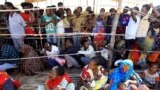 FILE - Ethiopians who fled fighting in the Tigray region gather to receive relief aid at the Um Rakouba camp on the Sudan-Ethiopia border, in Kassala state, Sudan, Dec. 17, 2020.