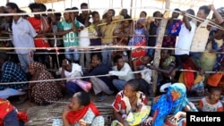 FILE - Ethiopians who fled fighting in the Tigray region gather to receive relief aid at the Um Rakouba camp on the Sudan-Ethiopia border, in Kassala state, Sudan, Dec. 17, 2020.