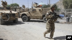 A US soldier, part of the NATO forces, patrols a police station after it was attacked by militants in Kandahar, south of Kabul, Afghanistan, June 19, 2012.