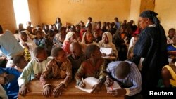 Children listen to a school teacher after the reopening of Mahamane Fondogoumo elementary school in the town center of Timbuktu, Feb. 1, 2013.