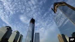 One World Trade Center, center, rises above the National September 11 Memorial and Museum at the World Trade Center, Thursday, Sept. 6, 2012 in New York. Tuesday will mark the eleventh anniversary of the terrorist attacks of Sept. 11, 2001. The World Fina