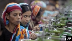 In this Saturday, Dec. 8, 2012, photo, Bangladeshi garment workers manufacture clothing in a factory on the outskirts of Dhaka, Bangladesh.