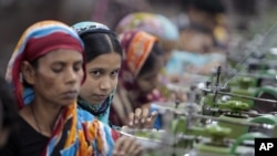 Bangladeshi garment workers make clothing in a factory on near Dhaka, Bangladesh, Saturday, December 8, 2012.