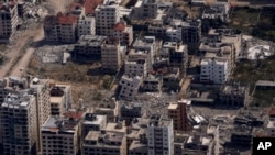 FILE—Destroyed buildings are seen through a window of an airplane from the U.S. Air force overflying the Gaza Strip, March 14, 2024.