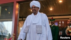 Sudanese President Omar al-Bashir walks out of a hotel in Abuja, Nigeria, July 14, 2013. 