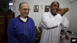 Cuba's dissident Angel Moya, right, speaks on the phone next to fellow dissident Hector Maseda, left, after being released from jail in Havana, Cuba, February 12, 2011.