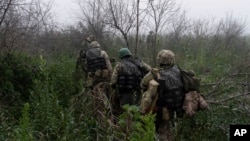 烏克蘭海軍陸戰隊隊員沿著第聶伯河附近的前線地區穿越樹林。（2023年10月14日）