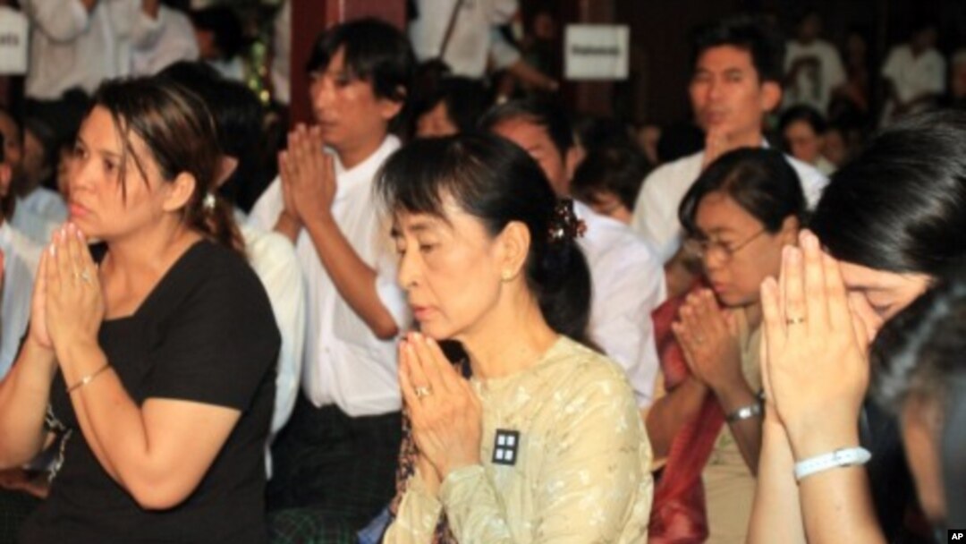 Burma's democracy icon Aung San Suu Kyi, center, and members of her National League for Democracy Party (NLD) pay respects to Buddhist monks during the 23rd anniversary of the 1988 uprising that was brutally crushed by Burma's military, at a monastery on