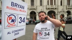FILE - Bryan Russell takes a call as he campaigns for Congress in Lima, Peru, Dec. 13, 2019.