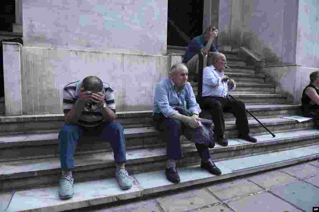 Elderly people, who usually get their pensions at the end of the month, wait outside a closed bank in the northern Greek port city of Thessaloniki, June 29, 2015.