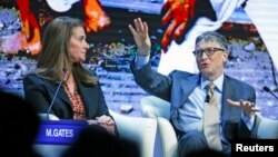 Bill Gates, Co-Chair of the Bill & Melinda Gates Foundation, gestures next to his wife Melinda French Gates during the session 'Sustainable Development: A Vision for the Future' in the Swiss mountain resort of Davos, Switzerland, Jan. 23, 2015.