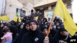 A woman carries a Hezbollah flag during the funeral of persons killed when hundreds of paging devices exploded in a deadly wave across Lebanon the previous day, in Beirut's southern suburbs on September 18, 2024.