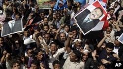 ພວກສະໜັບສະໜຸນປະທານາທິບໍດີເຢເມນ ທ່ານ Ali Abduallah Saleh ຖືຮູບແລະຮ້ອງຄຳຂວັນຊົມເຊີຍທ່ານ ໃນລະຫວ່າງການໂຮມຊຸມນຸມ ສະເຫຼີມສະຫຼອງການກັບຄືນ ສູ່ນະຄອນຫຼວງ Sanaa ຂອງທ່ານ (23 ກັນຍາ 2011)