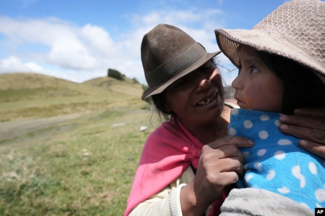 A Native woman soothes her daughter before giving her a flu shot in Cotopaxi, Ecuador on December 2, 2022. (AP Photo/Dolores Ochoa)