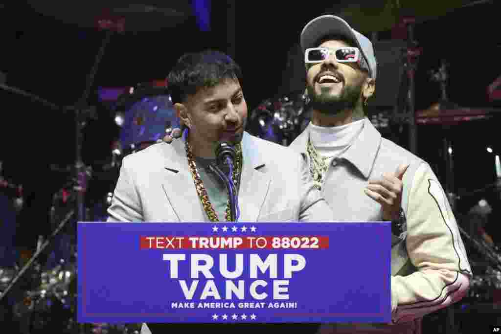 Los artistas puertorriqueños Anuel AA y Justin Quiles hablan durante el mitin del presidente electo de EEUU, Donald Trump, el día antes de su toma de posesión para un segundo mandato, en Washington.