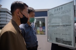 People read an article condemning anti-Pyongyang leaflets sent across the border by South Korean activists, at a news stand in Pyongyang on June 6, 2020.