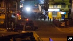 Congolese riot police take position around the electoral commission building at night in Kinshasa, Congo, Jan. 8, 2019.