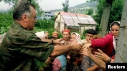 ARHIVA - Komandant vojske bosanski Srba Ratko Mladić, pruža hranu bosanskim muslimanima, izbeglicama iz Srebrenice 12. jula 1995. (Foto: Reuters)